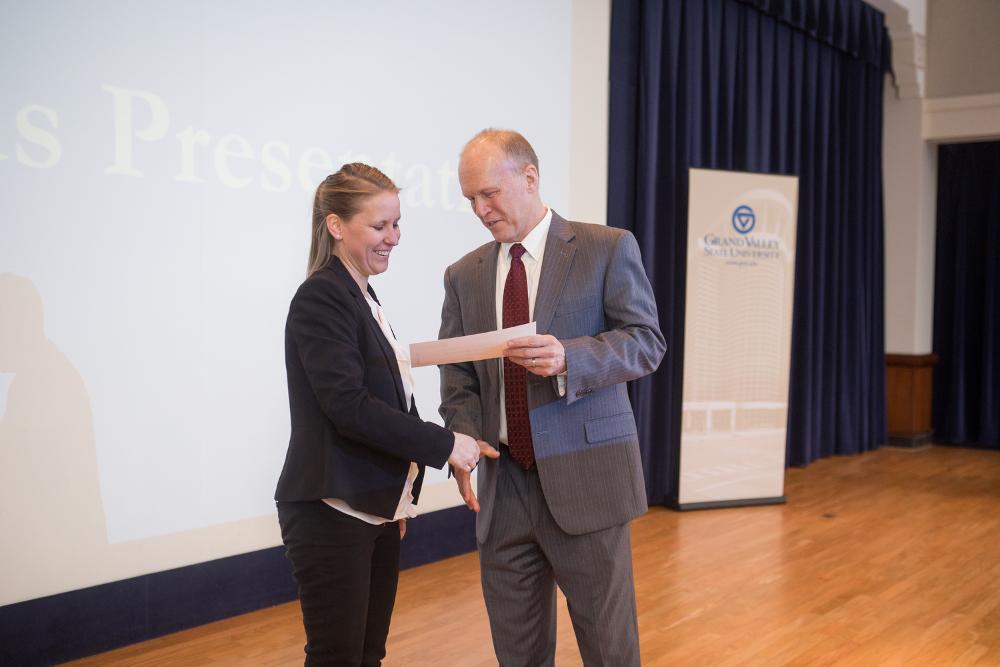 3MT First Place winner Kathryn Ellens shaking hands with the Dean of The Graduate School